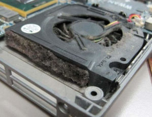 Ventilateur d'un PC encrassé par de la poussière en cours de nettoyage